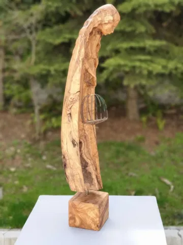 "Tutsak" eseri HAKAN ERASLAN tarafından 2018 yılında 71x21x16 cm ölçülerinde Zeytin Ağacı Yontu tekniği ile yapılmıştır.
