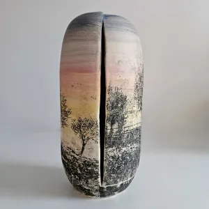 OLGU SÜMENGEN BERKER tarafından 2023 yılında 11,5x11,5x27 cm ölçülerinde Stoneware çamur, tornada şekillendirme, sıraltı boya ve pigmentler transfer baskı, 1220 °C pişirim tekniği ile yapılmıştır.